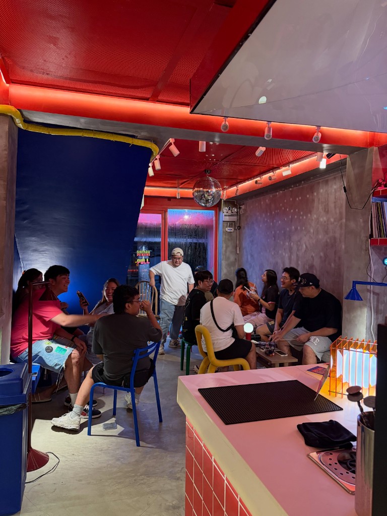 People hanging out in Holy Sip with a blue wall and red ceiling.